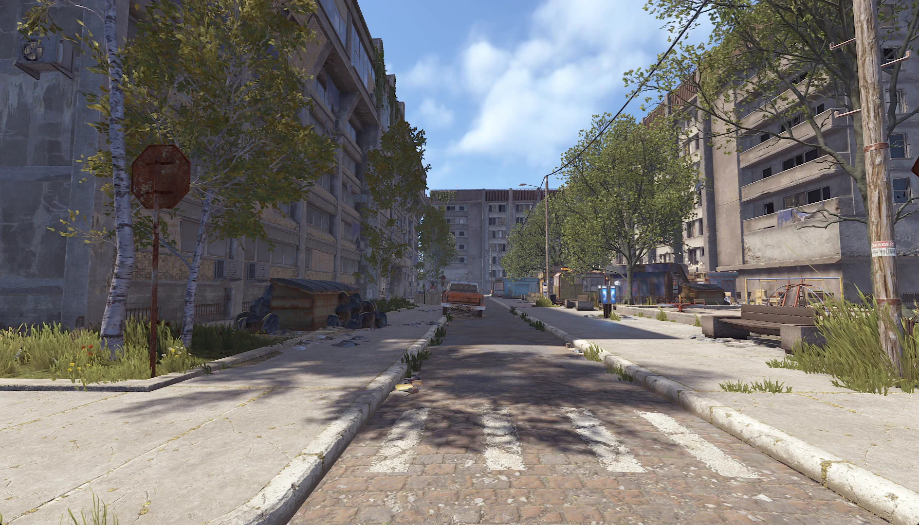 Улица заброшенного города в Rust: жилые дома, деревья и ржавая машина